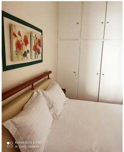 雅典Ομορφο διαμέρισμα κοντά στο σταθμό Δουκίσσης Πλακεντίας的卧室配有一张床,墙上挂有绘画作品