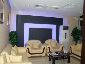 马斯喀特萨沃伊格兰特公寓式酒店的客厅配有白色家具和大屏幕电视