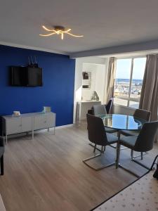 洛斯克里斯蒂亚诺斯CORNELIAS HOME TC1 vista marina的客厅设有蓝色的墙壁和桌椅