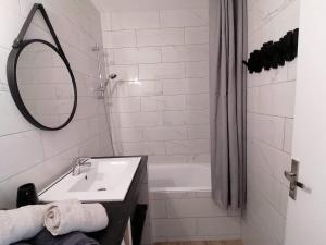 第戎Appartement centre ville avec parking privatif的浴室配有盥洗盆、镜子和浴缸