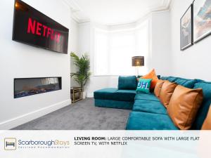 斯卡伯勒Scarborough Stays - Trafalgar Lodge - 4 bedroomed house - Free Parking的客厅配有蓝色的沙发和电视
