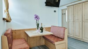 利维尼奥Hotel 2000的一张桌子,上面放着一瓶葡萄酒和一瓶紫色花卉