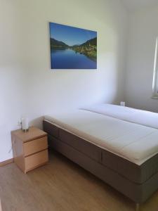 魏森湖Ferienhäuser Seetraum的卧室内的一张床铺,墙上挂着一幅画
