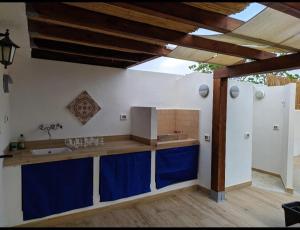 卡洛福泰Cottage a 1km dal centro storico, 500 m dal mare,veranda attrezzata, giardino,vista mare的厨房配有水槽和带蓝色橱柜的台面。