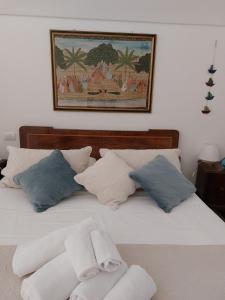 莫诺波利Sea and Tradition b&b的一张带枕头的白色床和墙上的照片