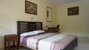 乌布Nyuh Gading Accommodation Ubud的卧室配有一张床和一张桌子及椅子
