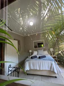 索德瓦纳湾Occi Lodge的一间卧室设有一张床和棕榈叶天花板