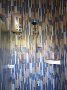 邦劳Peace Lily Studio Apartments Panglao的浴室设有淋浴头和瓷砖墙