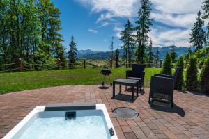 扎科帕内Peak Glamp的庭院内带桌椅的热水浴池。