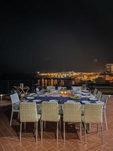 加利波利Salento Palace Bed & Breakfast的晚间在阳台上摆放着餐桌和椅子