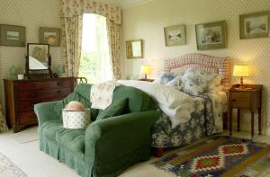 托玛斯镇巴里杜夫乡村民宿的一间卧室配有一张床和一张绿色沙发