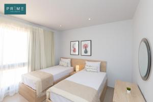 马特鲁港Prime Holidays Caesar Bay的酒店客房设有两张床和一张桌子。