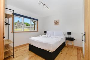 伯青顿The Piggery, Quex Park Estate的白色的卧室设有床和窗户