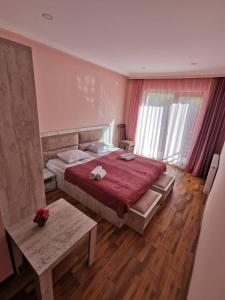 梅斯蒂亚Hotel Ramaz Paliani的一间卧室配有一张带红色毯子的大床