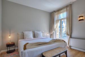 尼斯Maison Lamartine - Nice的白色的卧室设有一张大床和一个窗户