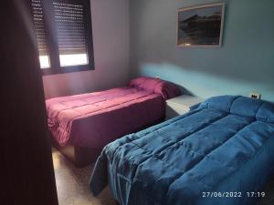 博伊罗A Casa do Lolo的一间卧室设有两张床、一个窗口和床边