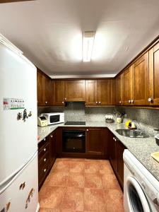 里亚尔普Apartamento Raval - L'Amfitriona的厨房配有木制橱柜和白色冰箱。