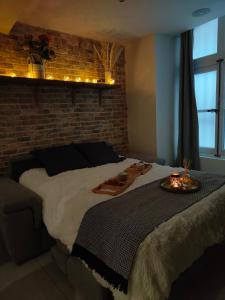 阿维尼翁Au Spa de LLEA的一间卧室设有一张大床和砖墙