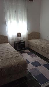 乌尔齐尼Lemon Tree的客房设有两张床、一张桌子和一扇窗户。