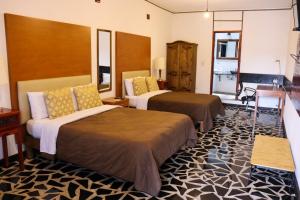 乔卢拉Hotel Vitorina Cholula的一间酒店客房,房间内设有两张床