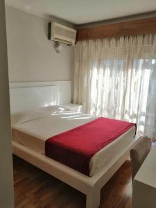 布拉干萨克拉西斯酒店的一间卧室配有一张带红色毯子的大床