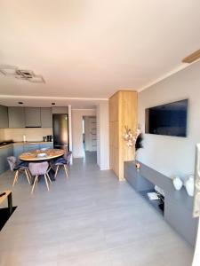 耶莱尼亚古拉Apartament Luxusowe Karkonosze的厨房以及带桌椅的起居室。