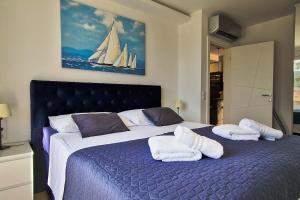 杜布罗夫尼克Aquamarine Deluxe Apartment的一间卧室配有一张大床和毛巾