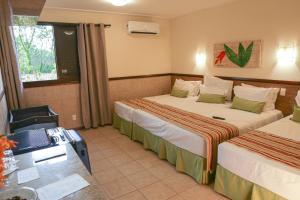 科内利乌-普罗科皮乌Aguativa Golf Resort的酒店客房配有两张床和一张书桌