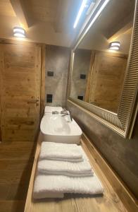加廖Il Falco Affittacamere的浴室配有盥洗盆、镜子和毛巾