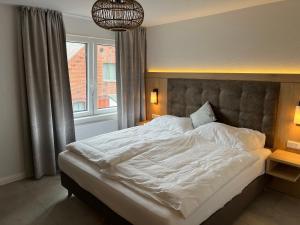 博尔库姆Haus Antina的一间卧室配有一张带白色床单的大床