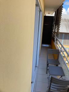 卡宴T2 COSY, LUMINEUX ET SPACIEUX的阳台配有椅子,楼梯与大楼相连