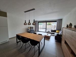 奥斯坦德Vakantiehuis Mariakerke的厨房以及带木桌和椅子的客厅。