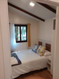 萨里亚Camping Vila de Sarria的一间卧室设有一张大床和窗户