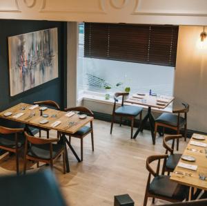 圣安德鲁斯Haar with Rooms 5 stars的餐厅设有木桌、椅子和窗户
