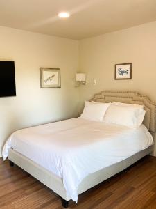西沃德Spruce Lodge的一间卧室配有一张带白色床单的床和一台电视。
