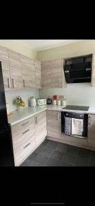 威克NC500, Wick Caithness Holiday Home的厨房配有木制橱柜和炉灶烤箱。