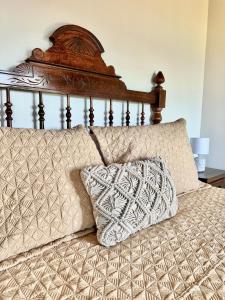 Claverol卡萨丘吉尔酒店的一张带木制床头板和枕头的床