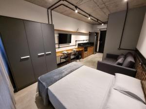 伊达贾伊APTO Studios的一间卧室配有一张床、一张沙发和一台电视。