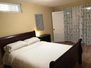 多伦多Spacious 2 Bedroom guest suite的一间卧室配有一张带白色床单的床和一扇窗户。