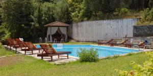 达西亚Habitat Villa Corfu的一组椅子坐在游泳池旁