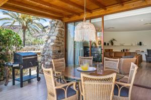 拉普拉亚蒂陶洛Gran Tauro Villa的一个带桌椅和烧烤架的庭院