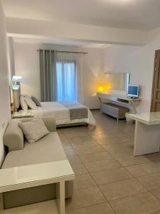 圣爱奥尼斯米科诺斯斯派罗斯&弗洛拉力托斯酒店的一间卧室配有一张床、一张沙发和一张书桌