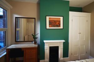 温彻斯特Boscobel Apartments Up的绿色的客房设有镜子和壁炉