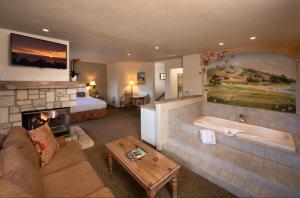 卡梅尔地平线海景酒店的客厅设有壁炉、床和浴缸。
