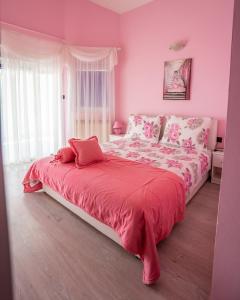 比比涅Apartments Villa Rudi的粉红色的卧室配有一张带红色毯子的大床