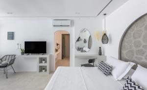 阿达玛斯Calma Suite Milos的一间白色卧室,配有床和电视