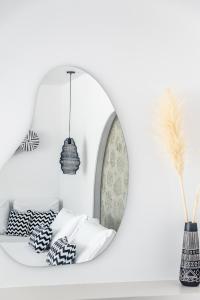 阿达玛斯Calma Suite Milos的白色客房,配有镜子和枕头,位于架子上