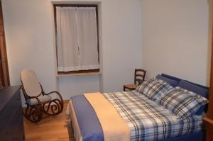阿尔巴阿尔菲里公寓的卧室配有床、椅子和窗户。