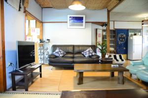 宫古岛Accommodation Limited to One Group Per Day Yukuiru的客厅配有真皮沙发和桌子