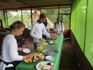 伊基托斯Amazon Jaguar Adventure的一群人站在桌子旁吃着食物